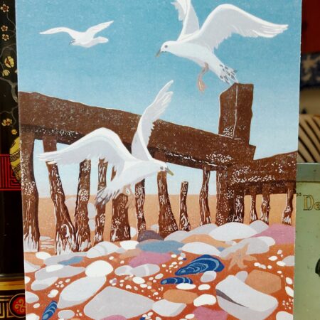 Close up of blank greetings card with sea birds flying above the shore
