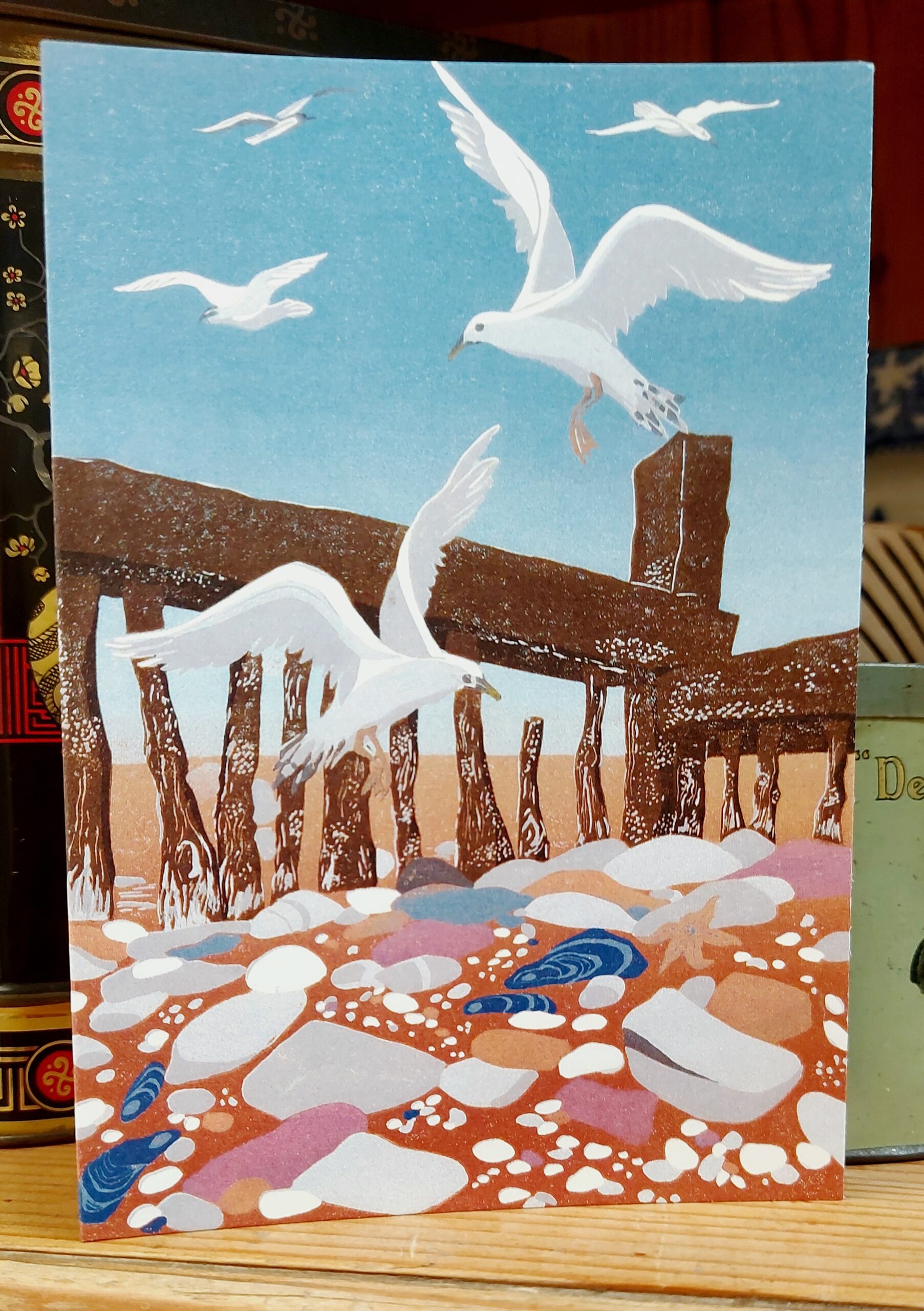 Close up of blank greetings card with sea birds flying above the shore